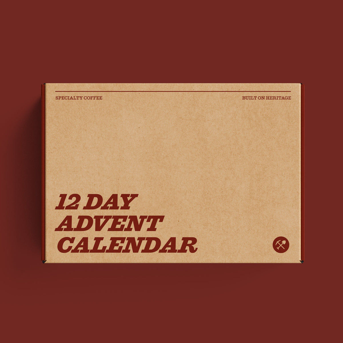 A flat-lay view of a cardboard box for a '12 Day Advent Calendar' by Specialty Coffee, set against a solid dark red background.
