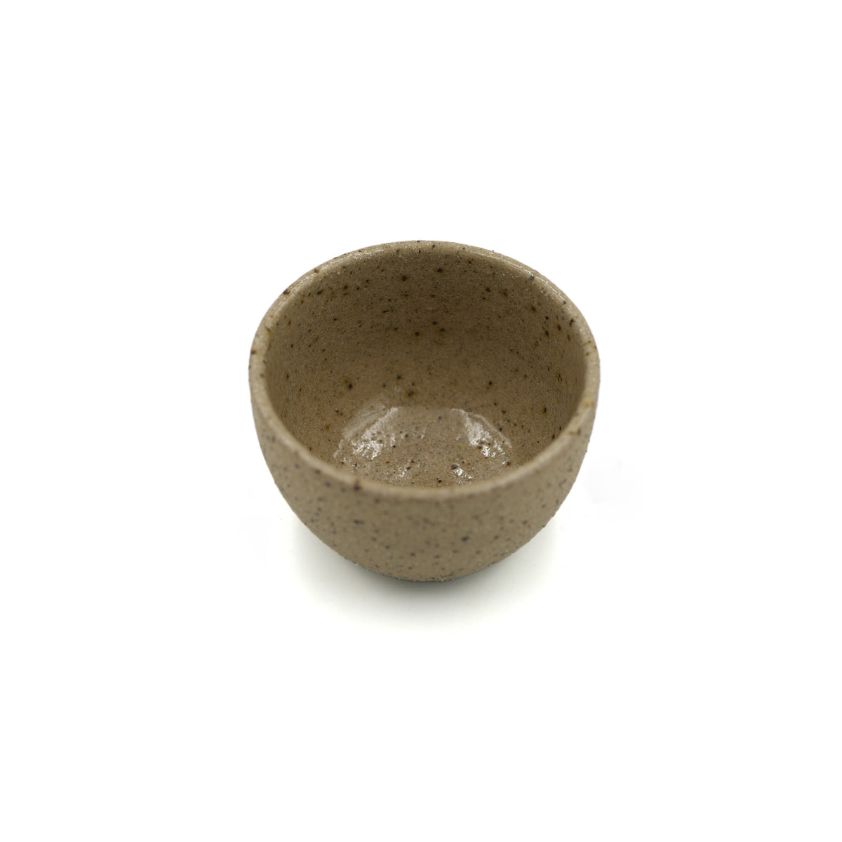 A small handmade ceramic cup with a speckled taupe-brown glaze, shown from a top-down view on a white background.