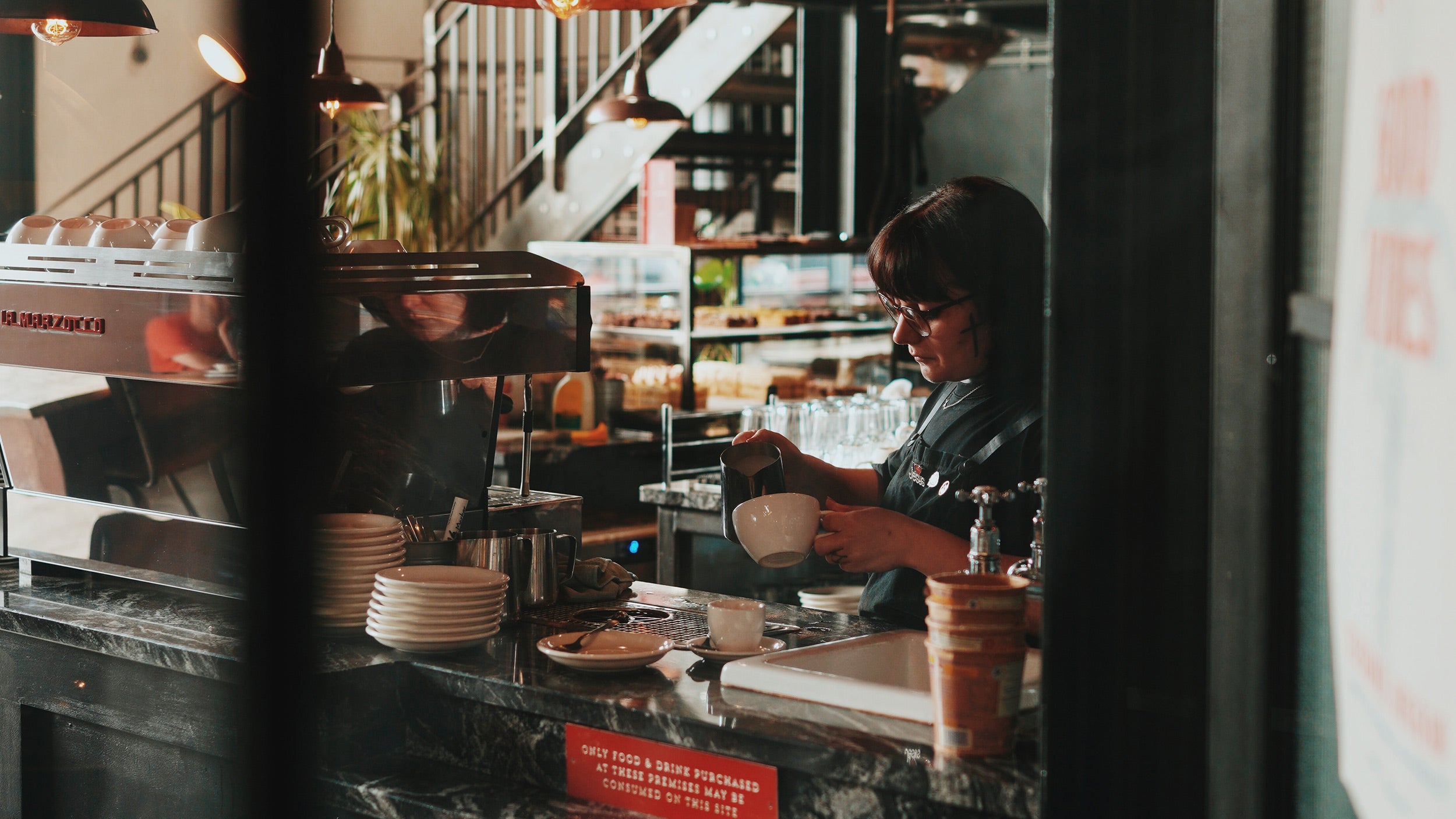 Career At Coaltown Coffee Espresso Bar. Barista making coffee on the espresso bar for customers in a cafe.
