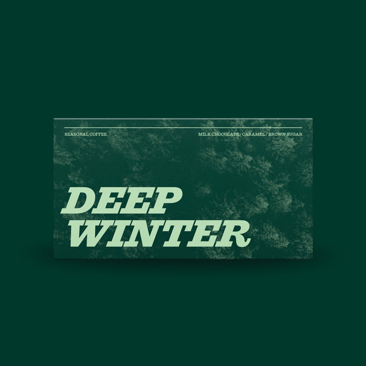 A rectangular coffee package centered on a dark green background. The package has a textured dark green design with large pale green text reading 'DEEP WINTER' and smaller text at the top including 'SEASONAL COFFEE' and flavor notes 'MILK CHOCOLATE, CARAMEL, BROWN SUGAR'.