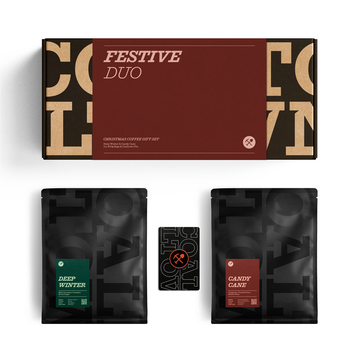 Festive Duo Christmas coffee gift set featuring a dark red and black box with gold lettering, alongside two black coffee bags labeled 'Deep Winter' and 'Candy Cane' with a small black card in the center, all on a white background.