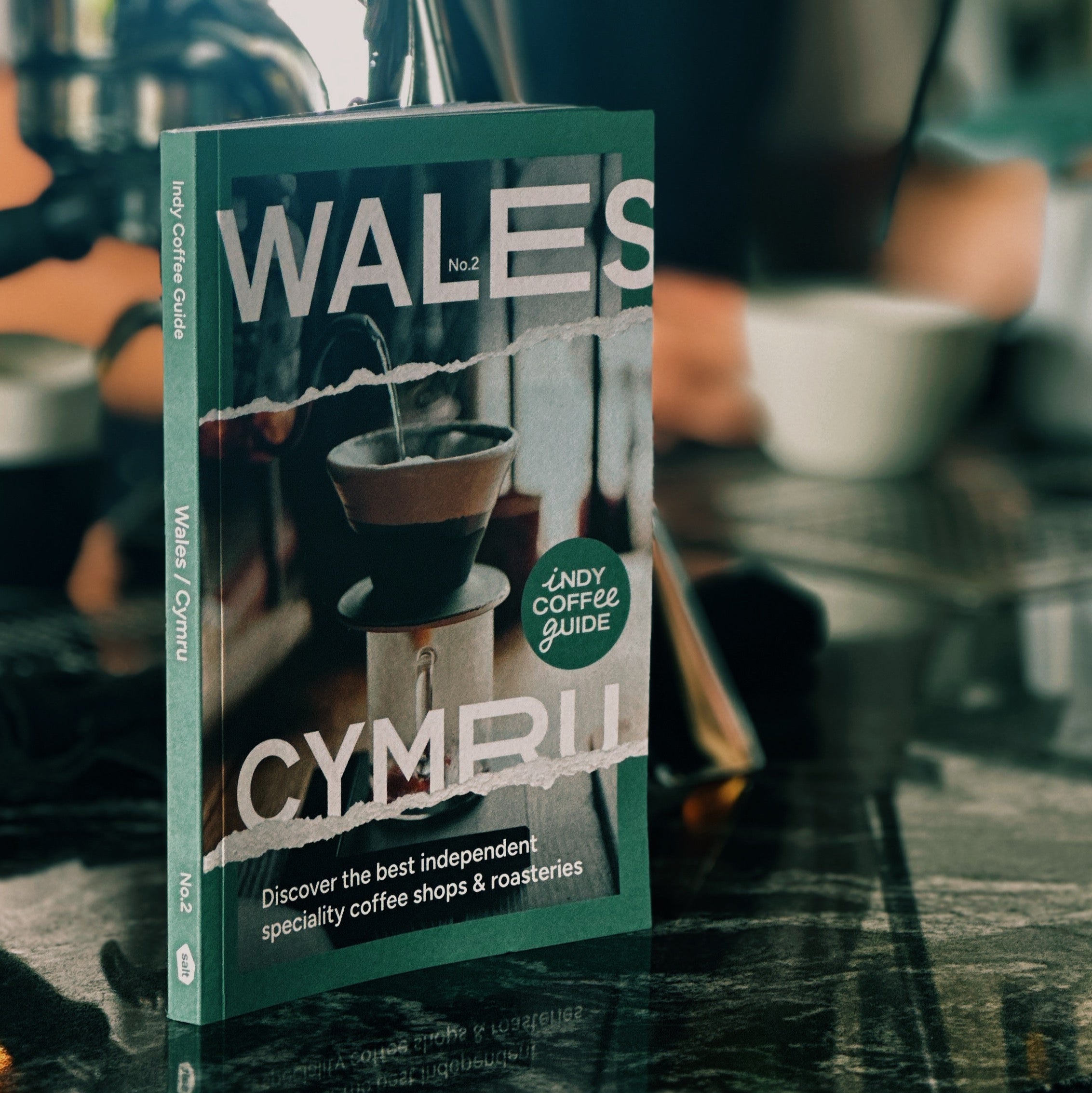 Book titled 'Wales Indy Coffee Guide' with a blurred person in the background