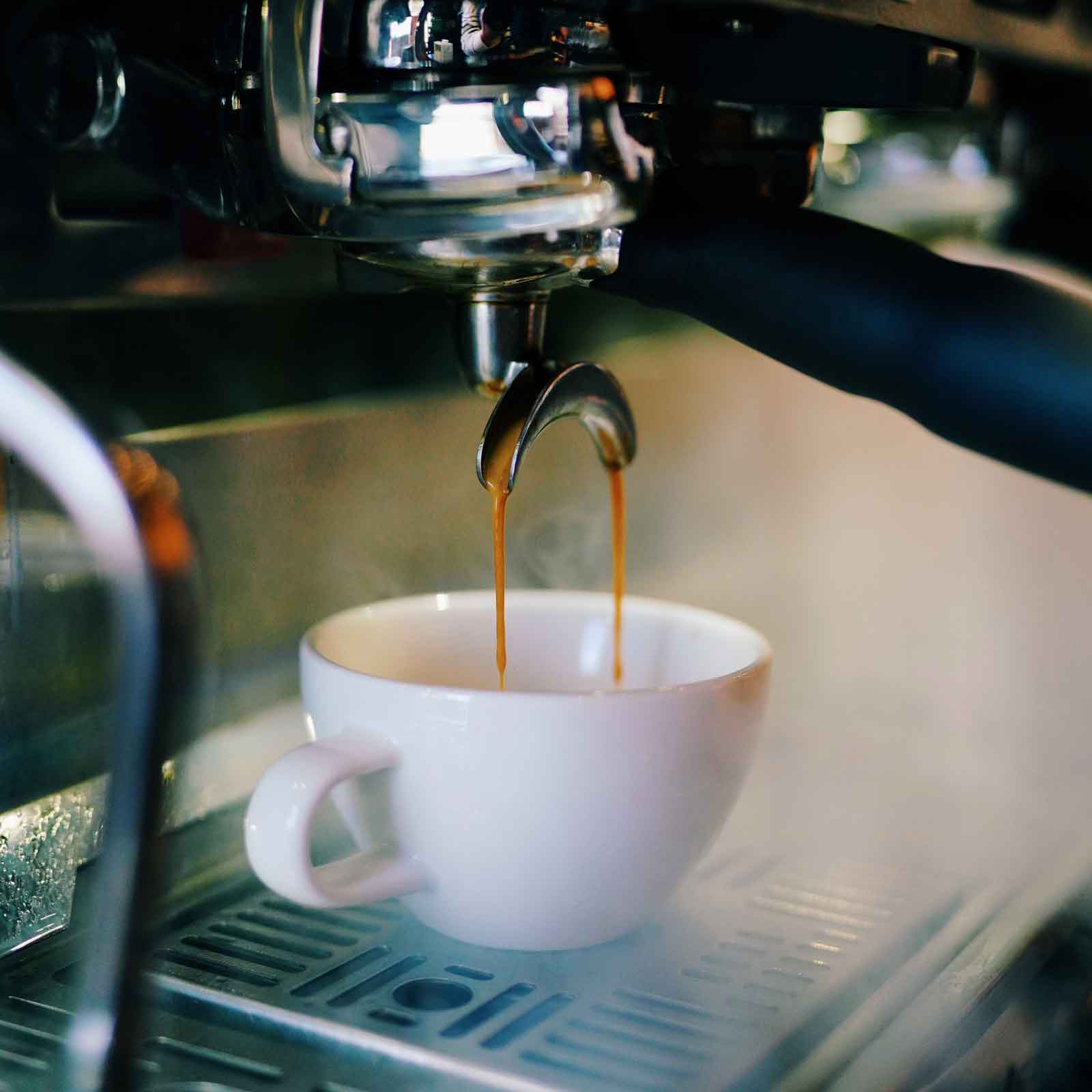 La Marzocco Espresso being poured from a machine into a white cup.